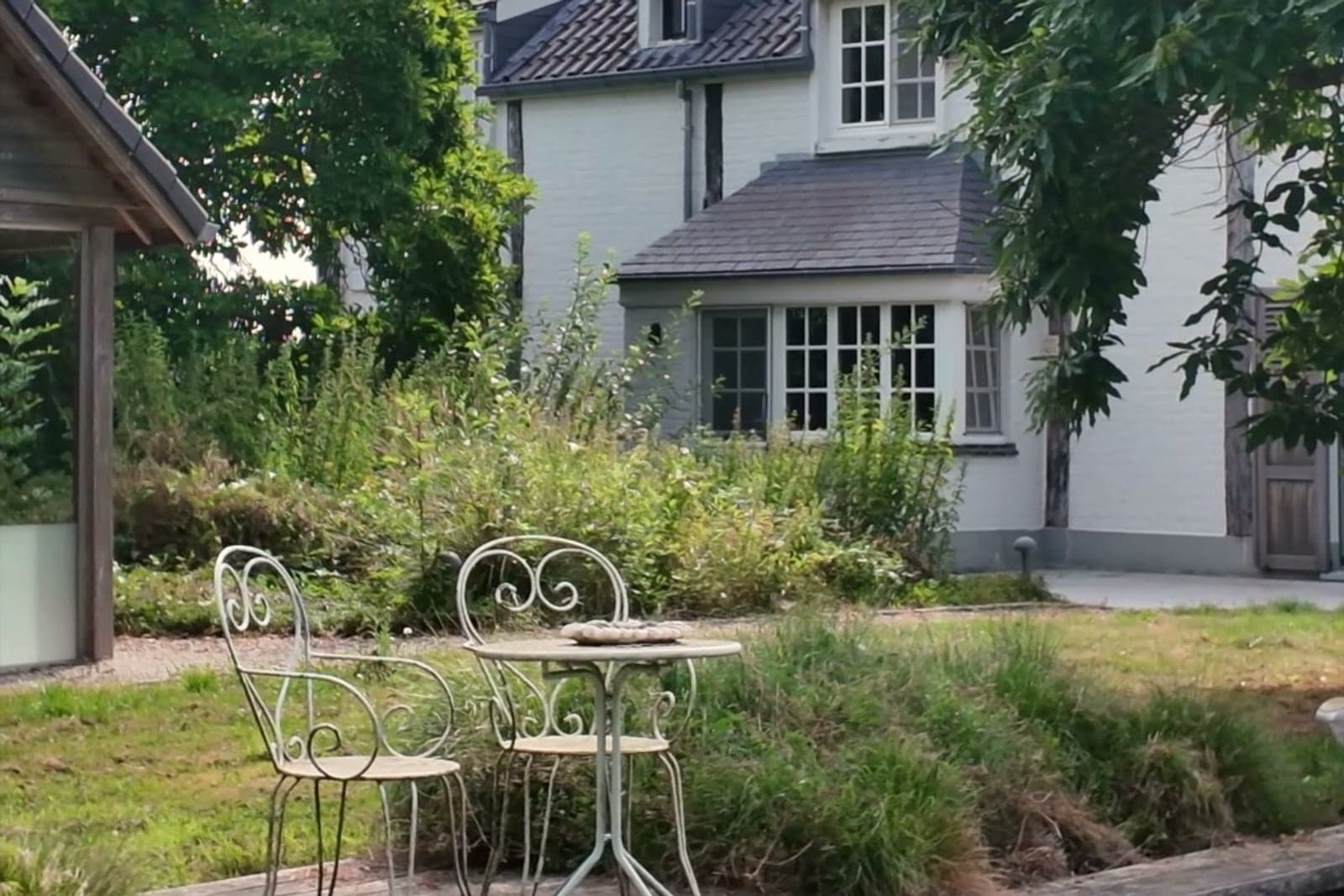 Een terras aan een vijver bij een landelijke woning