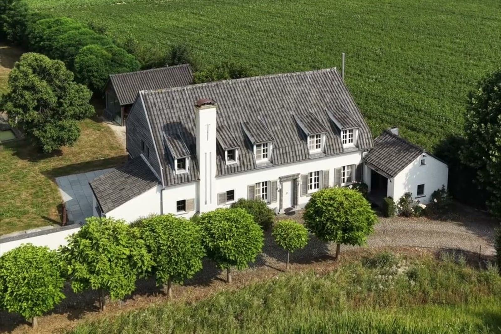 Dronebeeld van een landhuis op een ruim perceel tussen de velden