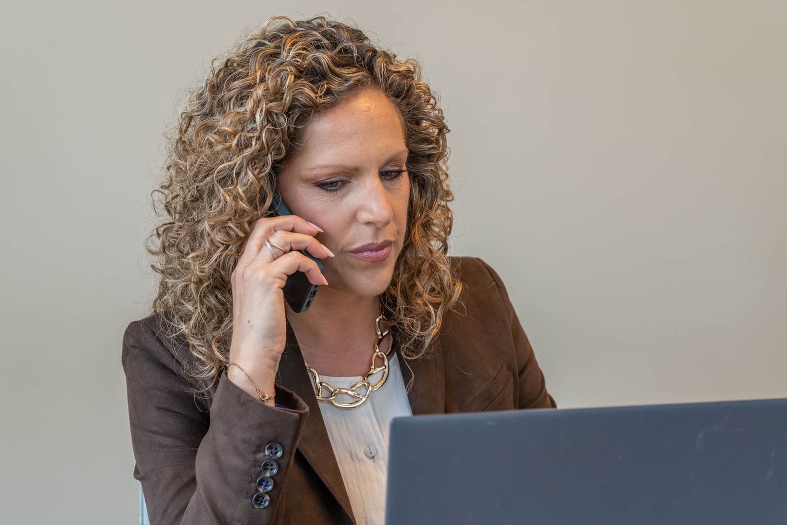 Tiziana belt een klant terug terwijl ze een waardebepaling nakijkt op haar laptop