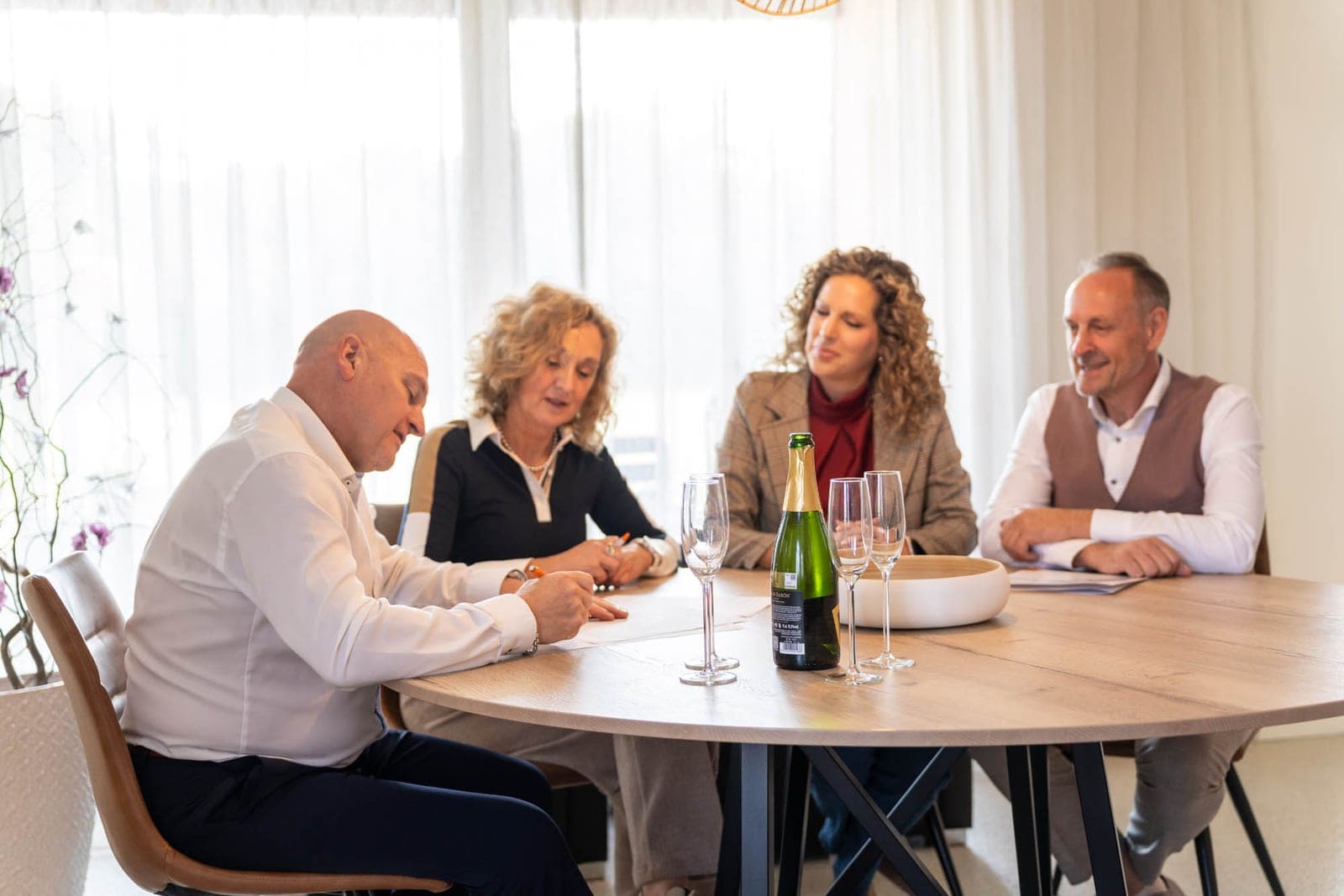 Verkopers, Tiziana en Hans rond de tafel bij de ondertekening