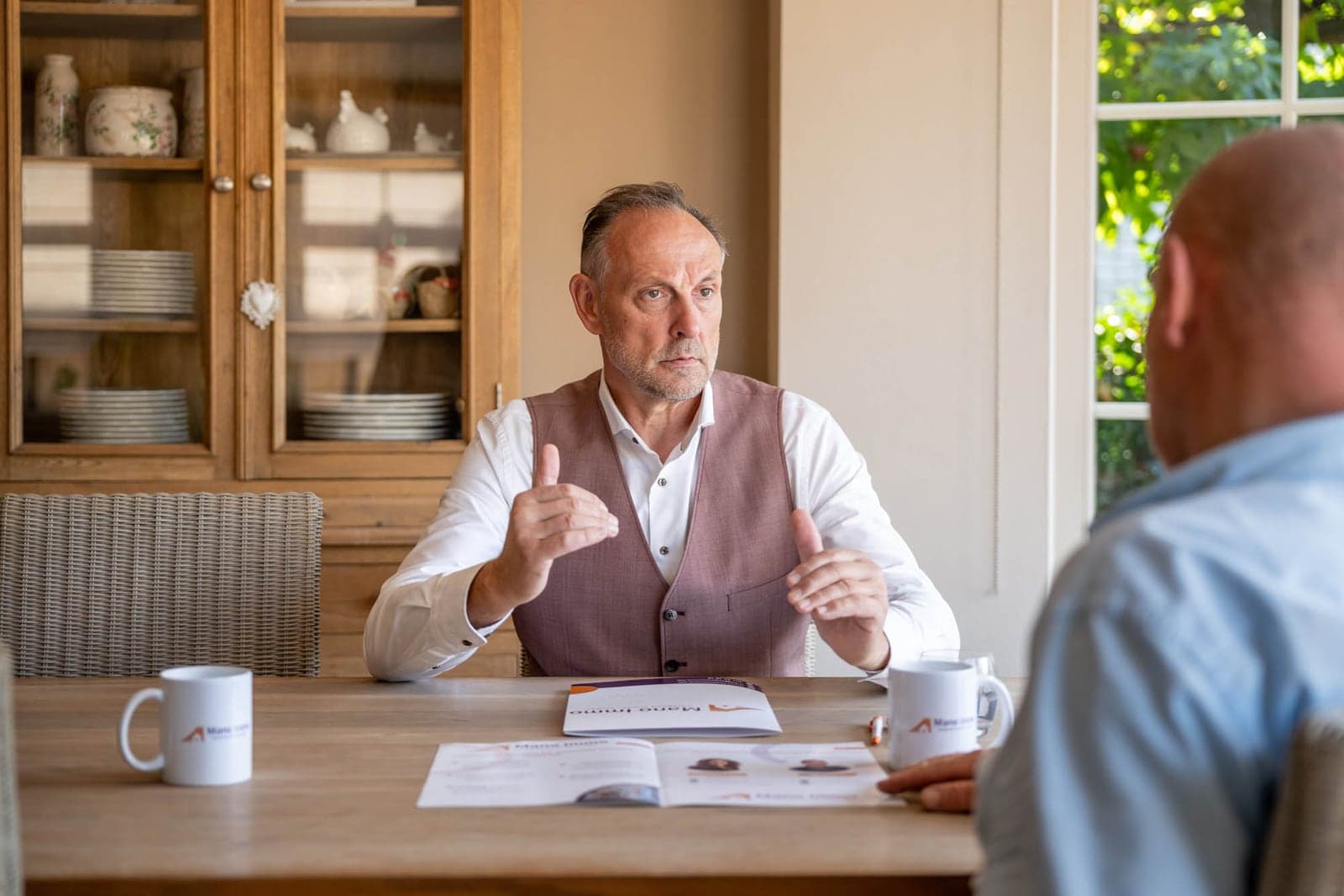 Hans licht aan tafel de vraagprijs toe aan een verkoper