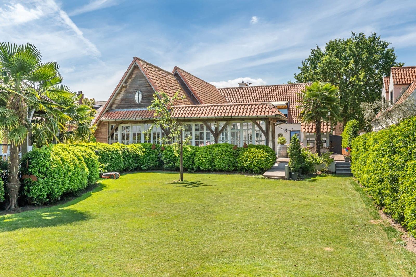 Een woning met een weelderige tuin in volle zon